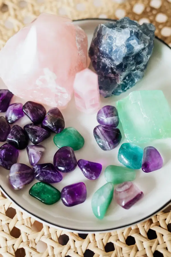 colorful healing crystals on a ceramic plate